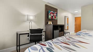 A hotel room with two beds, a desk, a chair, a television, and a microwave.