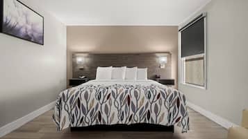 Un dormitorio moderno con cama, lámparas de noche y un ventanal grande.