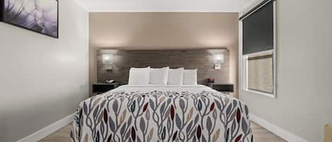 A modern bedroom with a bed, bedside lamps, and a large window.