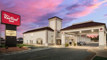 A Red Roof Inn with a sign indicating new rooms and a hot breakfast.