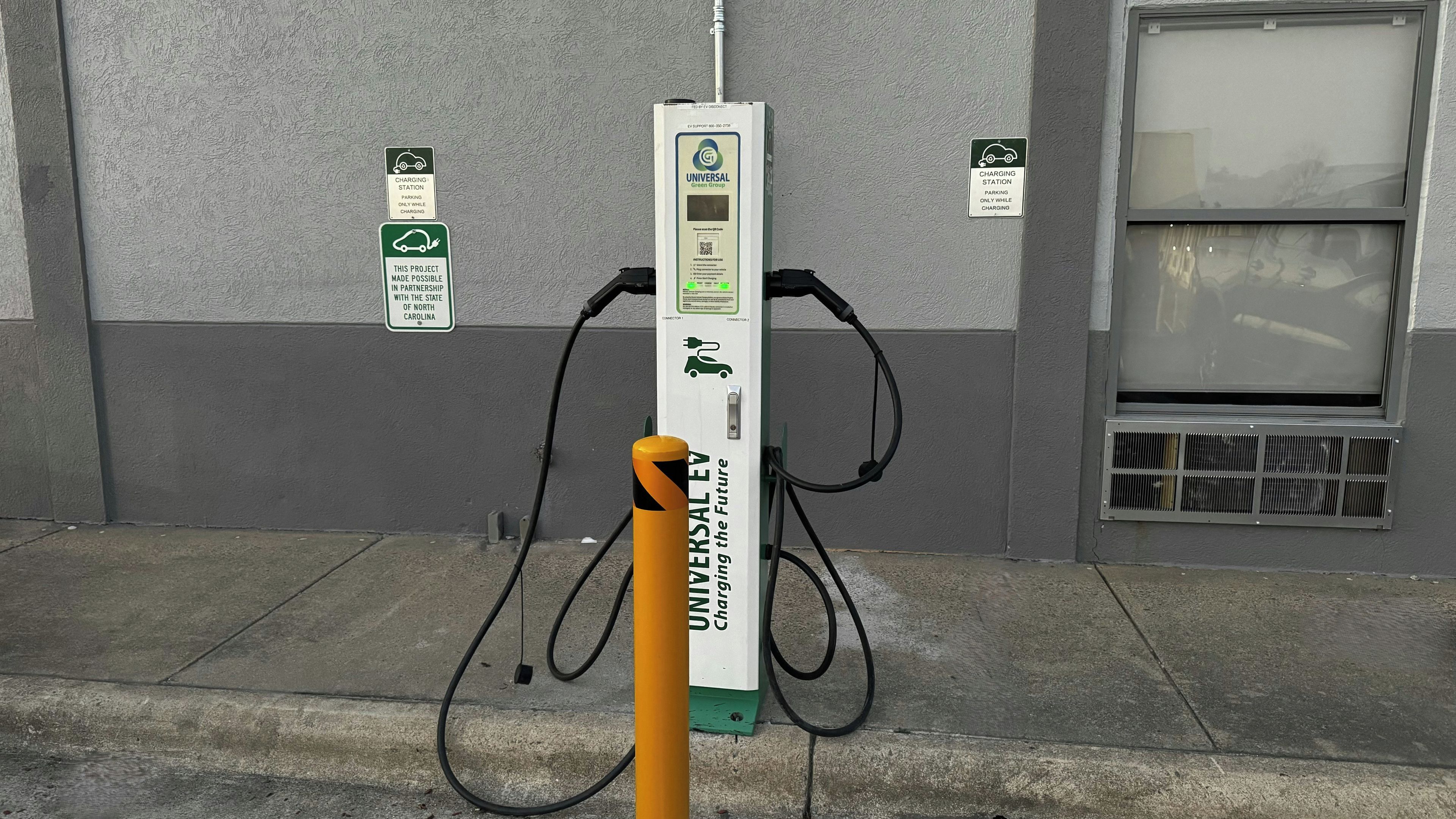 A charging station with a sign indicating it is a partnership with the State of North Carolina.