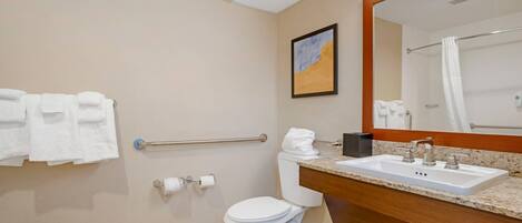A bathroom with a white toilet, a sink with a mirror, and a towel rack.