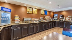 A hotel breakfast area with a self-service station, a refrigerator, and a coffee machine. - Comfort Inn Biltmore West (Asheville)