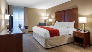 A hotel room with a bed, bedside tables, a desk with a computer, and a TV. - Comfort Inn Biltmore West (Asheville)
