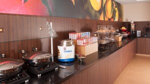 A breakfast bar with a large mural, a coffee machine, and various food items. - Fairfield Inn by Marriott Charlotte Gastonia (Gastonia)