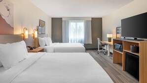A hotel room with two beds, a desk, a television, a microwave, and a small refrigerator. - Spark by Hilton Kannapolis (Kannapolis)