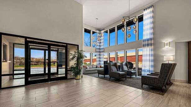 A spacious lobby with a large seating area, a potted plant, and a view of the outside. - Quality Inn & Suites Matthews - Charlotte (Matthews)