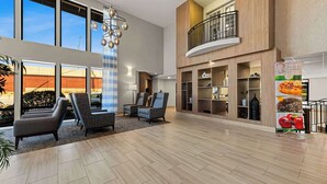 A spacious lobby with a high ceiling, large windows, and a modern chandelier. - Quality Inn & Suites Matthews - Charlotte (Matthews)