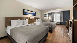 A hotel room with two beds, a desk, a chair, and a TV. - Quality Inn & Suites Matthews - Charlotte (Matthews)