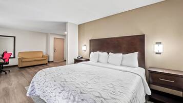 Una habitación de hotel con una cama grande, un sofá, un escritorio y una silla.