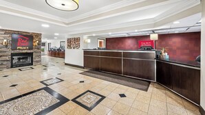 A hotel lobby with a reception desk, a fireplace, and a sign indicating free Wi-Fi availability.