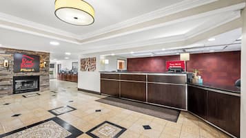 Vestíbulo de hotel con mostrador de recepción, chimenea y señalización de Wi-Fi gratuito.