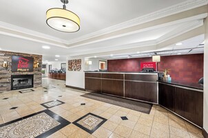 Vestíbulo de hotel con mostrador de recepción, chimenea y señalización de Wi-Fi gratuito.