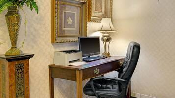 A wooden desk with a computer, a lamp, and a chair.