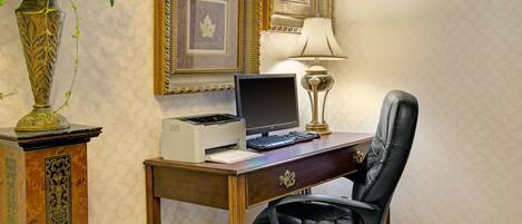 Un bureau en bois avec un ordinateur, une lampe et une chaise.