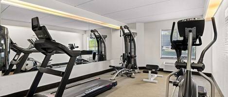 A gym with treadmills, elliptical machines, and weight equipment.