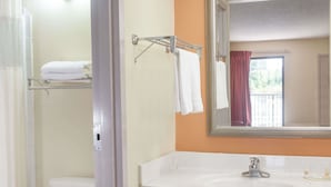 Ein Badezimmer mit einem weißen Waschbecken, einem Spiegel und einem Handtuchhalter.