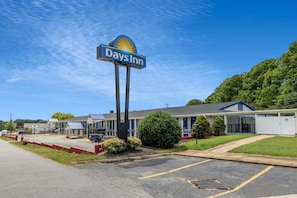 Un hotel Days Inn con un cartello ben visibile, un parcheggio e un edificio con tetto blu.