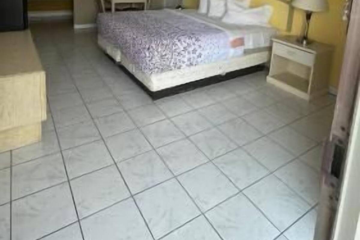 A bedroom with a bed, bedside tables, a desk, and a chair.