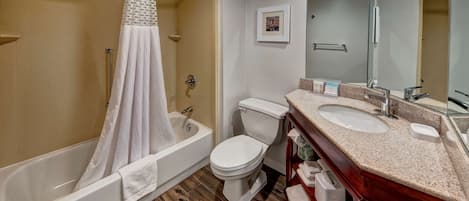 Une salle de bain équipée d’une baignoire, de toilettes et d’un meuble-lavabo avec un miroir.
