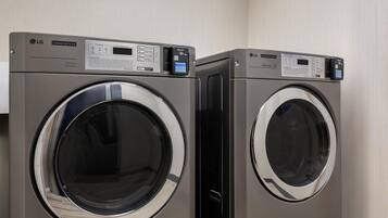 Two LG commercial dryers side by side in a laundry room.