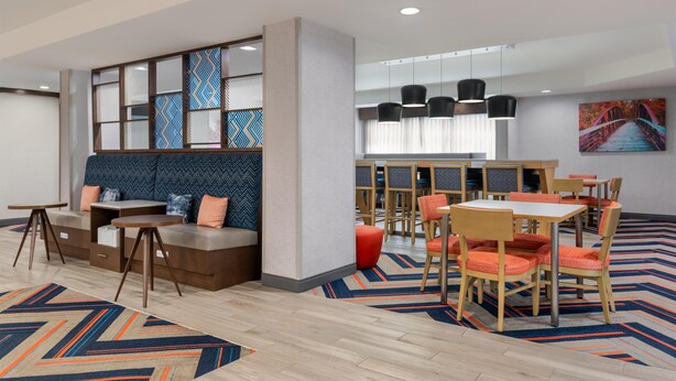 Eine moderne Hotelhalle mit Sitzgelegenheiten, Tischen und Stühlen.