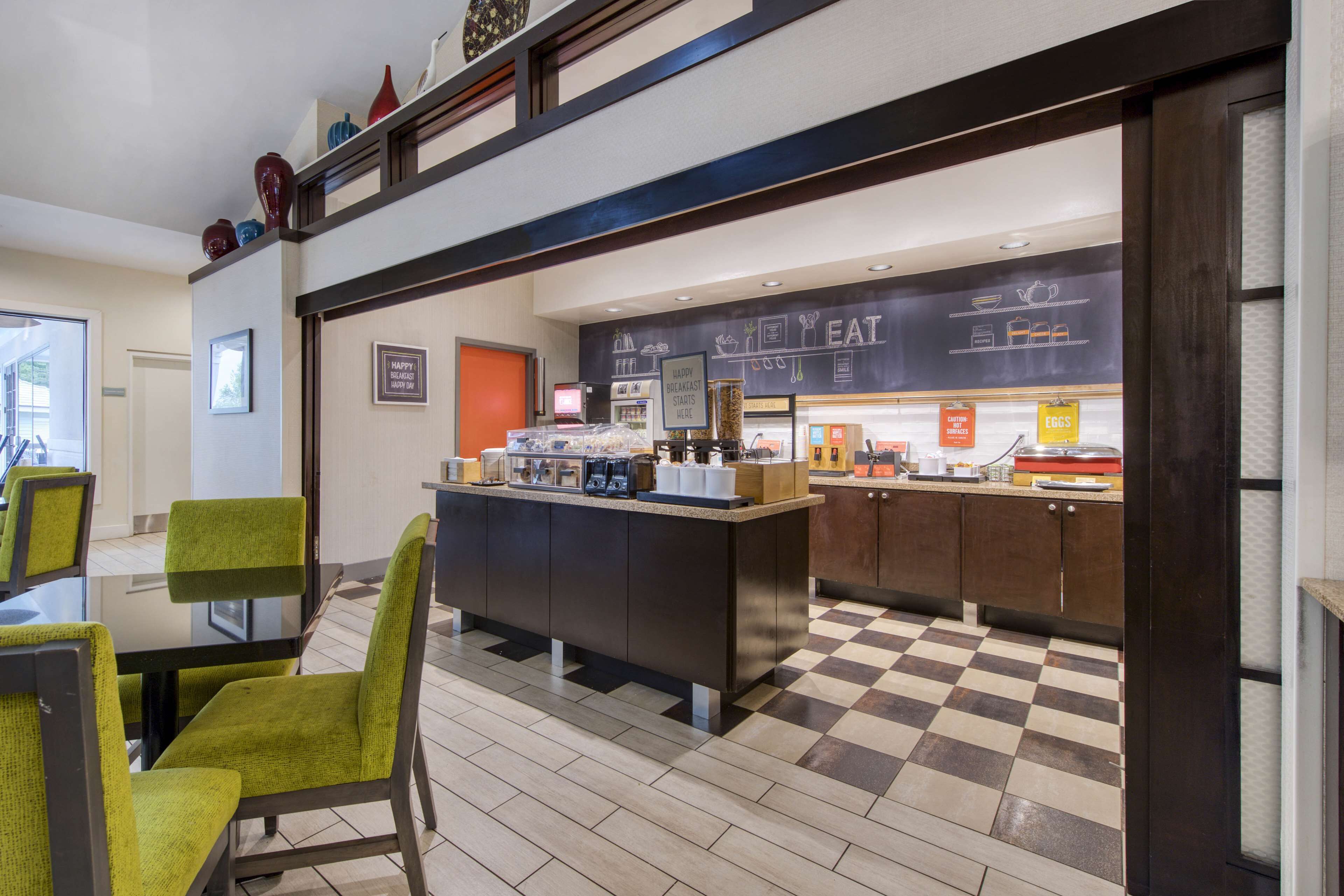 A breakfast bar with seating and a checkered floor.