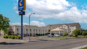 A Comfort Inn hotel with a parking sign, a parking lot, and a building with multiple windows and a flat roof. - Comfort Inn Bismarck (Bismarck)