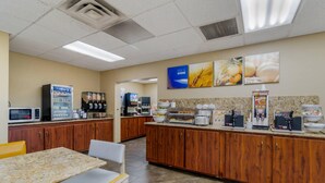 A kitchen area with a microwave, coffee machine, and a buffet setup. - Comfort Inn Bismarck (Bismarck)
