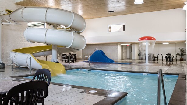 An indoor swimming pool with multiple slides and a seating area. - Comfort Inn Bismarck (Bismarck)