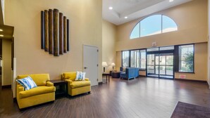 A spacious lobby with a high ceiling, a large arched window, and a modern design. - Comfort Inn Bismarck (Bismarck)