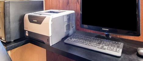 Un bureau d’ordinateur équipé d’une imprimante Brother, d’un écran Samsung et d’un clavier.