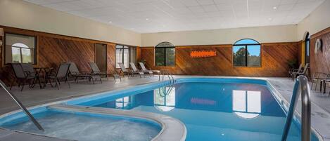 Una piscina interior con un cartel que indica 'no diving' de 60 centímetros, paredes de paneles de madera y ventanas con luz solar.