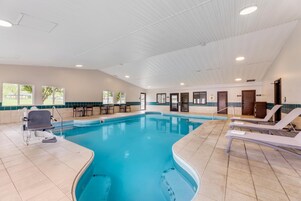 Una piscina techada, sillones reclinables de piscina