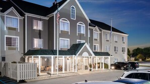 A large, multi-story hotel with a symmetrical facade, multiple windows, and a covered entrance area with outdoor seating.