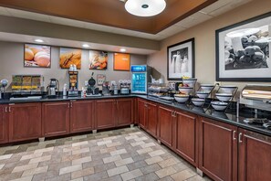 A well-equipped kitchen area with various appliances, a coffee machine, and food display.