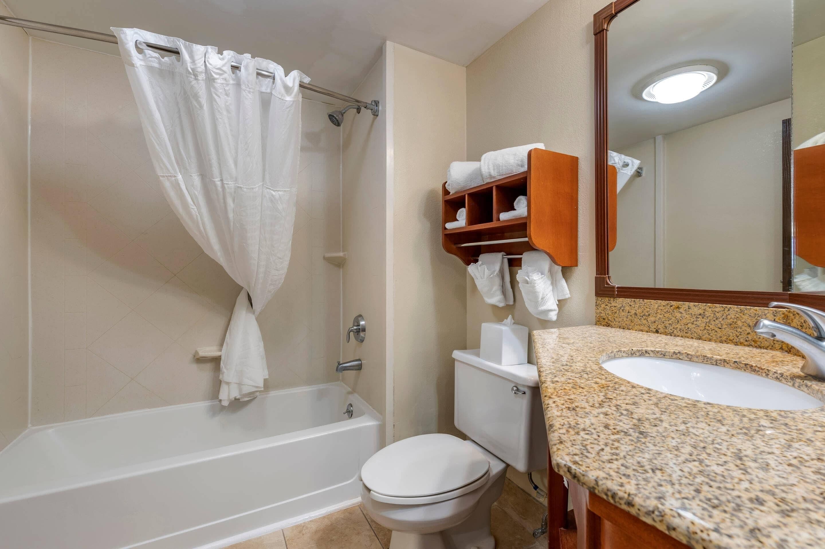 Un baño con bañera, inodoro y lavamanos.