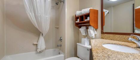 Un baño con bañera, inodoro y lavamanos.
