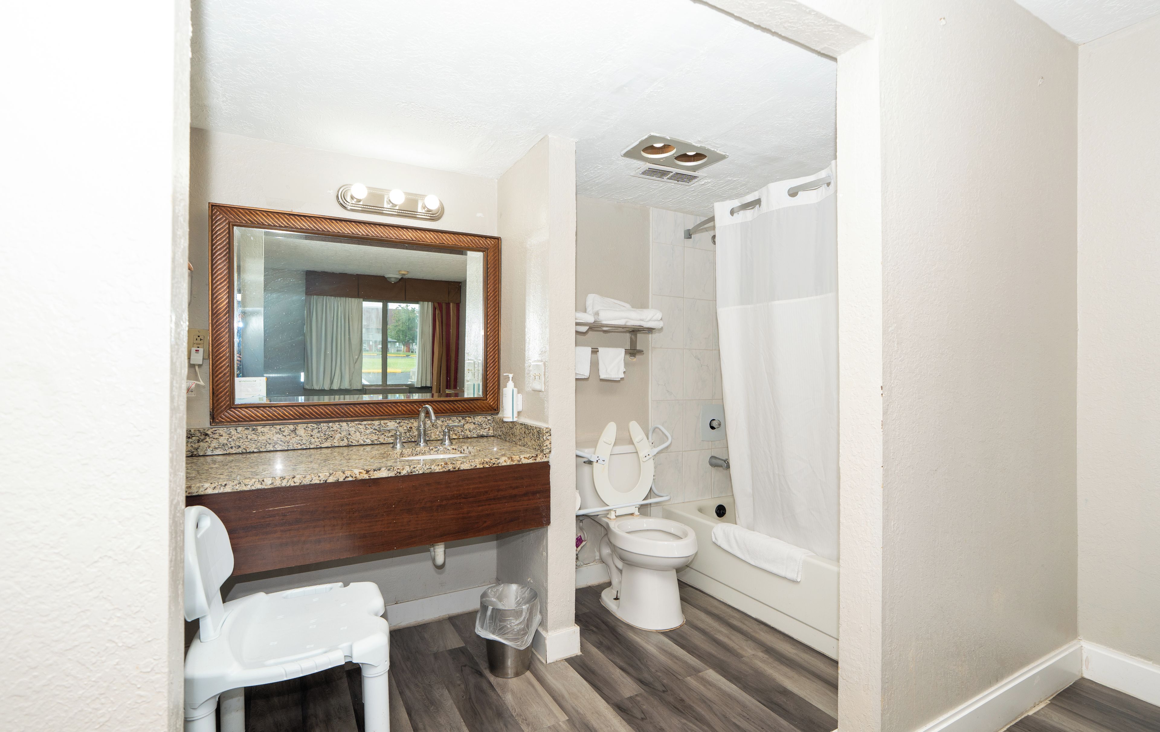 A bathroom with a sink, mirror, toilet, and shower.