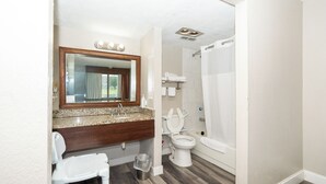 A bathroom with a sink, mirror, toilet, and shower. - Days Inn & Suites by Wyndham Dayton North (Dayton)