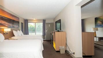Habitación de hotel con dos camas, televisión, escritorio y un cuadro en la pared.