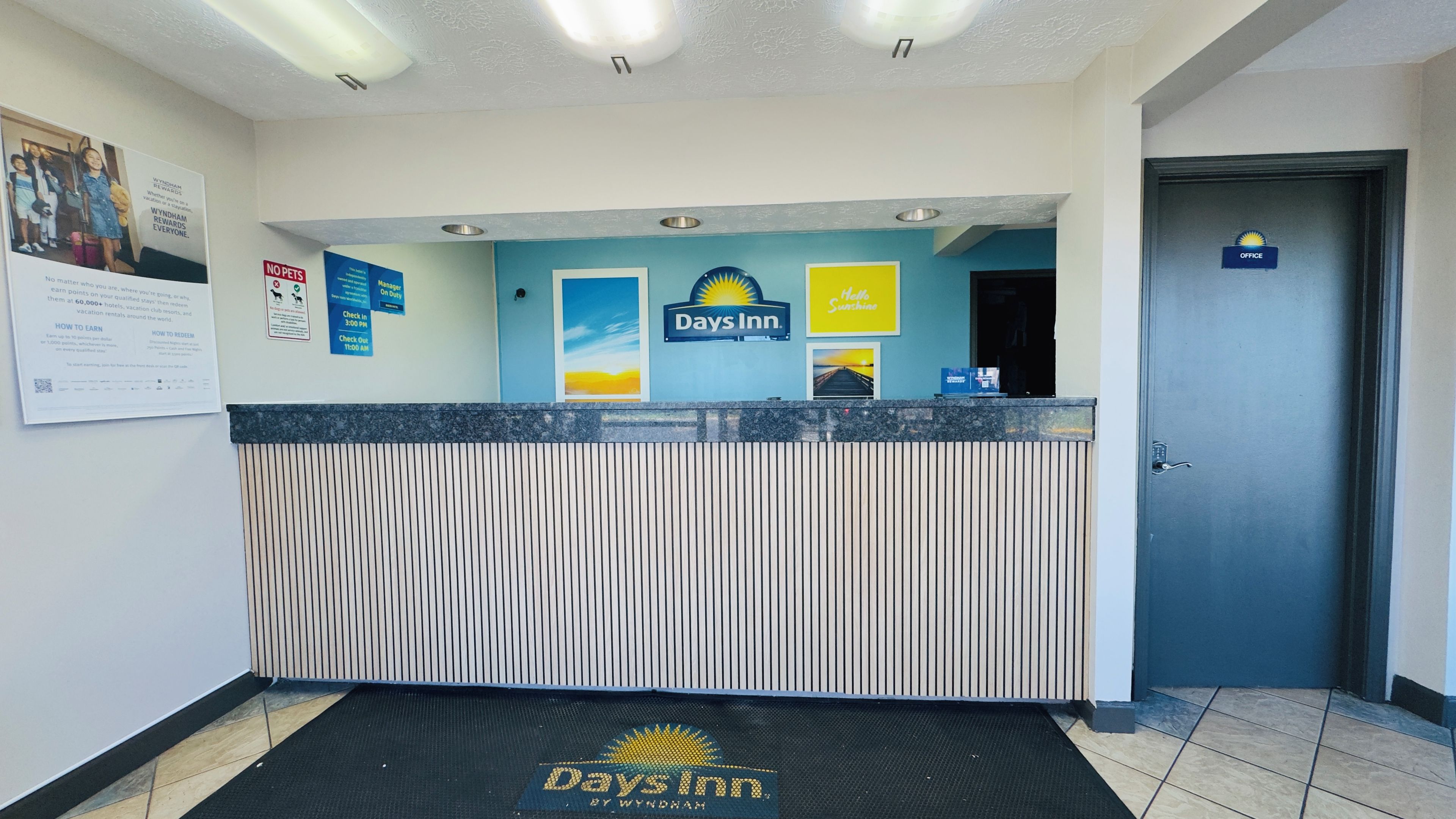 A reception area with a Days Inn sign, a 'No Pets' policy notice, and a 'Manager On Duty' sign.