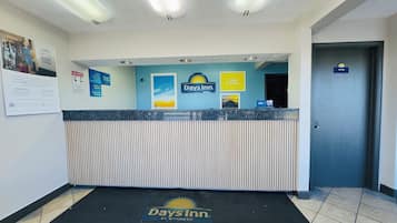 A reception area with a Days Inn sign, a 'No Pets' policy notice, and a 'Manager On Duty' sign.