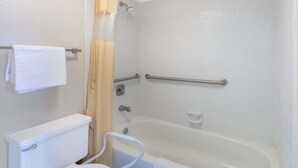 A bathroom with a white toilet, a bathtub, a shower with a curtain, and a grab bar. - Days Inn & Suites by Wyndham Dayton North (Dayton)