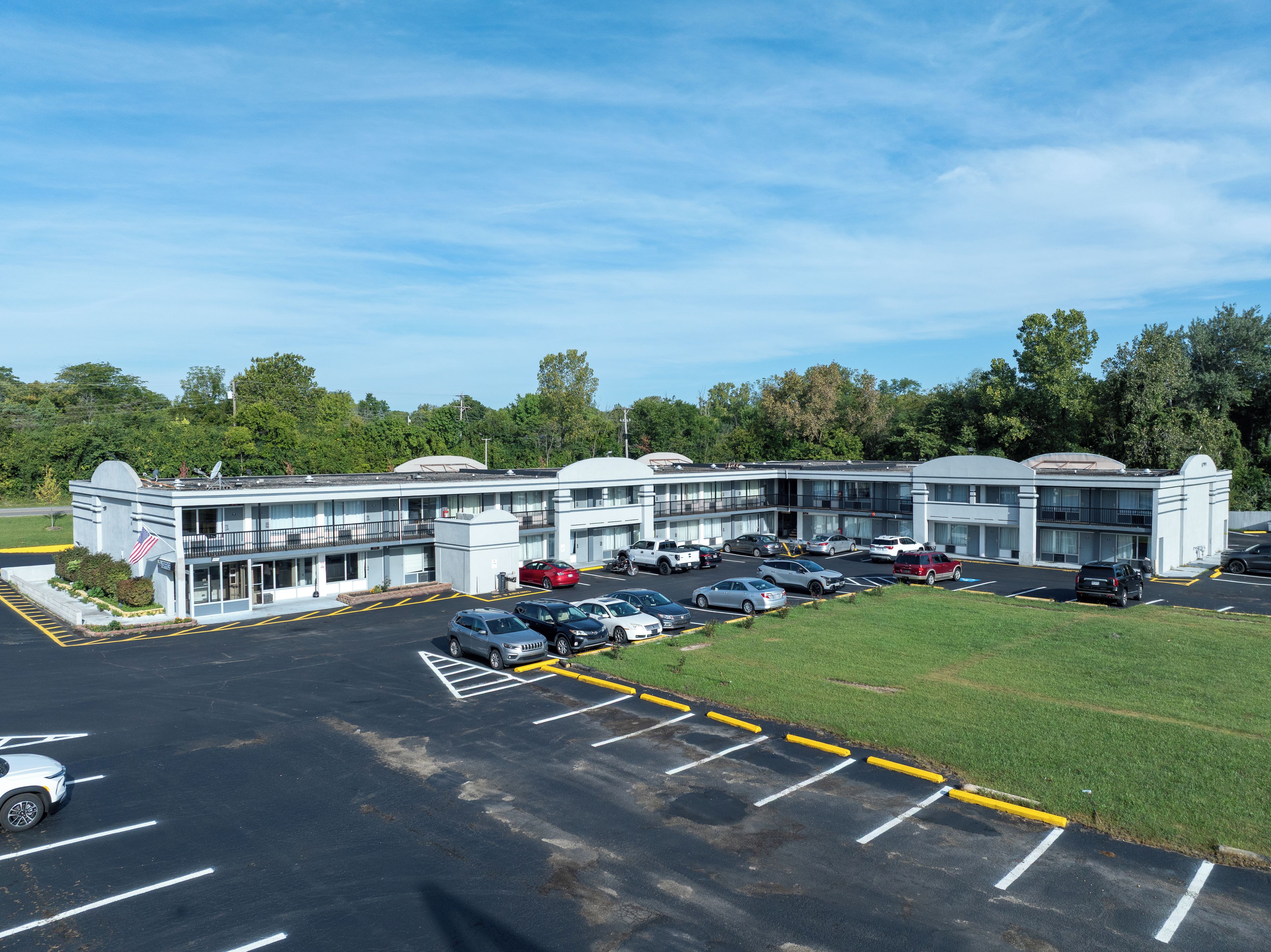 A multi-story parking garage with several levels of parking, surrounded by greenery and trees.