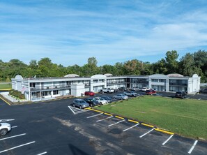 A multi-story parking garage with several levels of parking, surrounded by greenery and trees. - Days Inn & Suites by Wyndham Dayton North (Dayton)