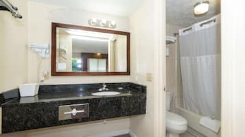 Un baño con lavamanos, espejo e inodoro.