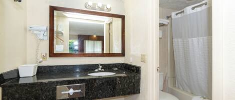 A bathroom with a sink, mirror, and toilet.