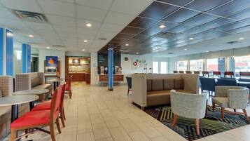 A modern cafe interior with seating arrangements, a coffee bar, and a view through the windows.