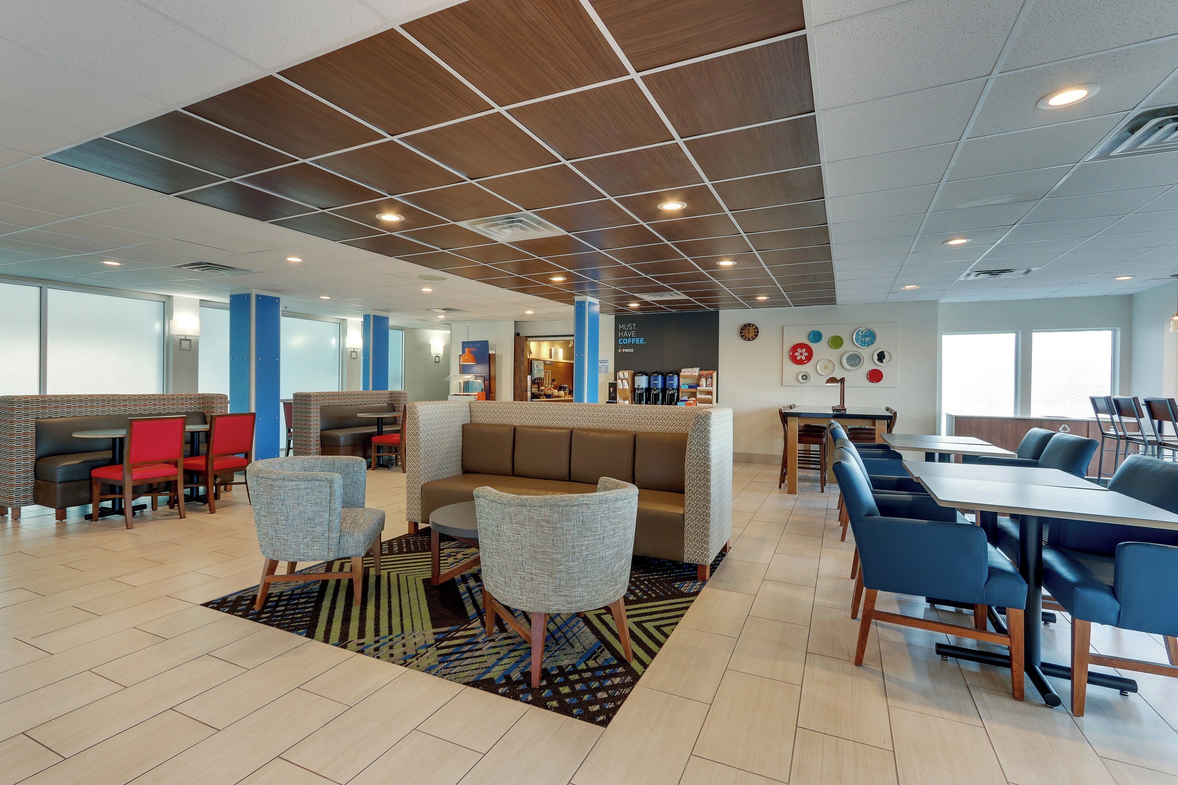 Un espace de détente moderne, aménagé avec des sièges confortables, un coin café et une horloge murale.